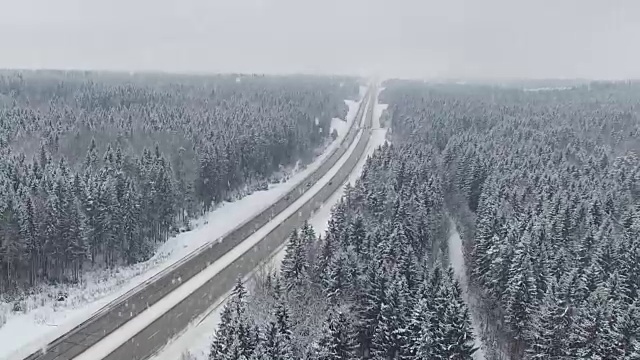 詳情圖-在冬天的森林里開著車在下雪。空中全景。消失點(diǎn)的角度來看