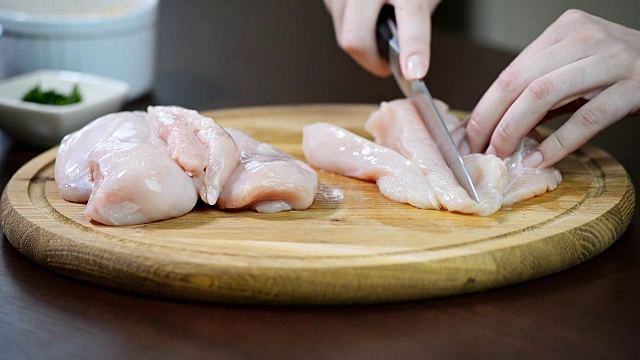 食物准备，烹饪概念。女用手切鸡胸肉切成片