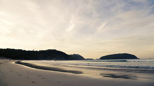 奈汉海滩上的日落。在山上看风力涡轮机。普吉岛,泰国