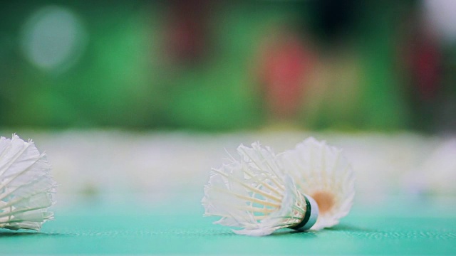 羽毛球在羽毛球场上与模糊的球员。