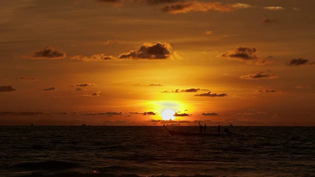 美丽的日落在奈罕海滩。一群人在船上经过。云景在橙色日落背景