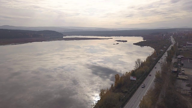 鸟瞰图卡车和汽车行驶在郊区道路上的河流背景