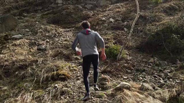 运动员在雪地里跑步。攀爬。真正的人成人越野跑运动训练是在秋冬野外山区自然，大雾天气恶劣的情况下进行的。4 k的视频