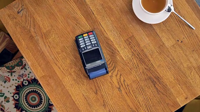 在NFC支付过程中从上面看到的咖啡杯和智能手机。