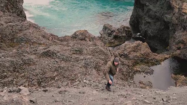 年轻英俊的男子独自徒步旅行。男旅人行走，独自爬过青山附近的蓝色湖泊
