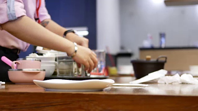 顾客在餐厅吃完食物后，工人正在清理桌子