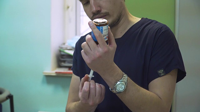 医生往注射器里塞药