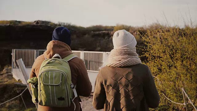 一对年轻夫妇一起走在山谷里。一男一女在探索冰岛的自然公园