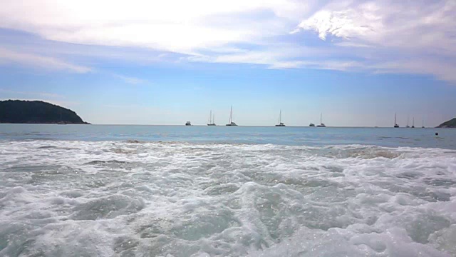慢动作海浪在沙滩上，海浪绿色的海洋或海洋在蓝色的绿色的天空或蔚蓝的天空。从沙滩上看到美丽的海景。