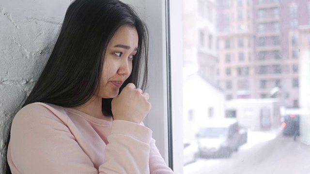 年轻亚洲妇女生病咳嗽，喉咙感染