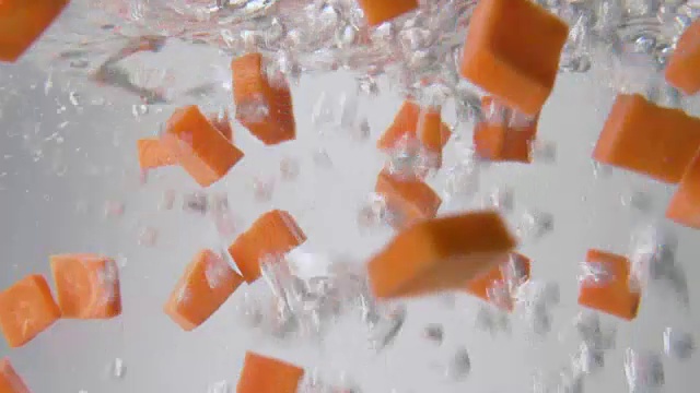 胡萝卜片落入沸水中。宏观视图