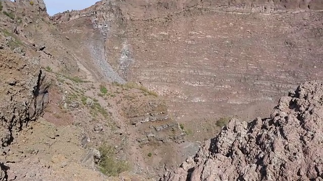陡峭的岩石峡谷斜坡与干燥稀少的植被在阳光下，序列