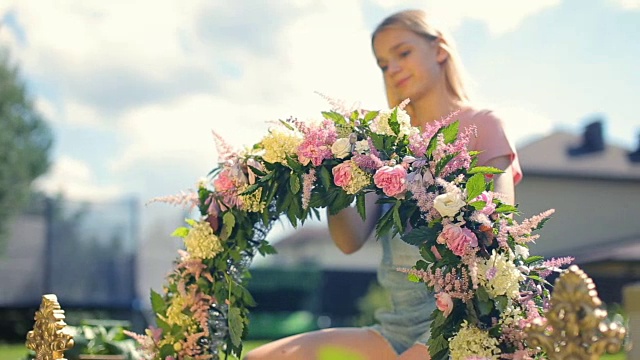 儿童课外活动花艺接待装饰课程——漂亮的女模特金发微笑的女孩用绿宝石草上的花朵做花的成分