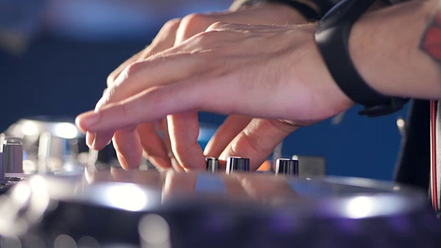 詳情圖-特寫鏡頭。唱盤后面的男dj。