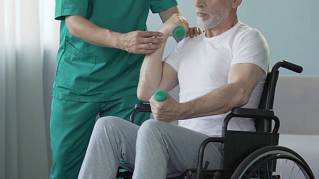 詳情圖-老人在輪椅上舉啞鈴，護士在他身邊幫助，外傷