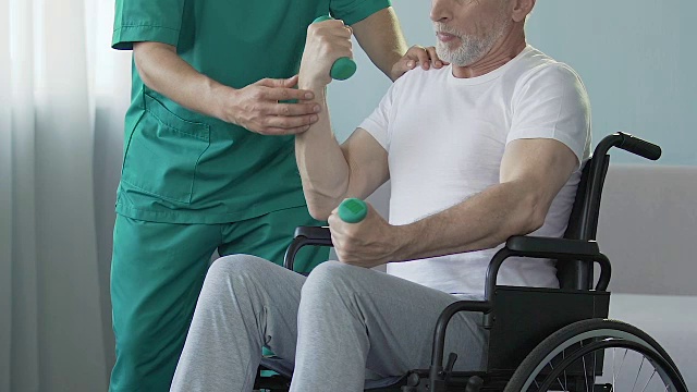 詳情圖-老人在輪椅上舉啞鈴，護士在他身邊幫助，外傷