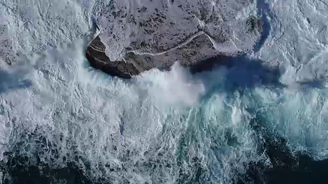 飞过黑山的绿色海浪拍打着岩石