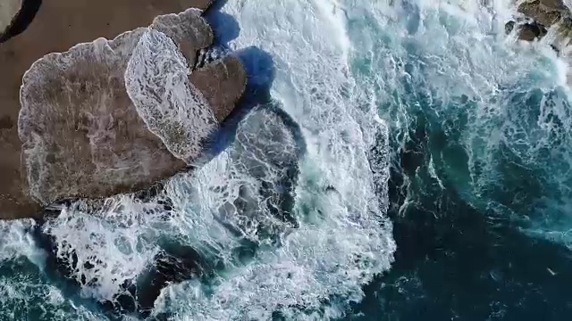 飞过黑山的绿色海浪拍打着岩石