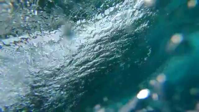 慢动作水下:水晶清晰桶波打破了摄像机在海洋