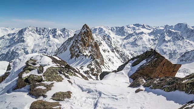 美丽的阳光明媚的冬日在雪山阿尔卑斯山。时光流逝摄影在雪山和雄伟的山峰上拍摄