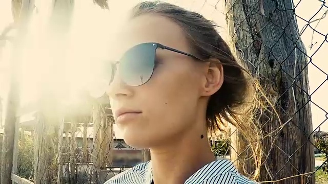 落日背景下戴着墨镜的女孩