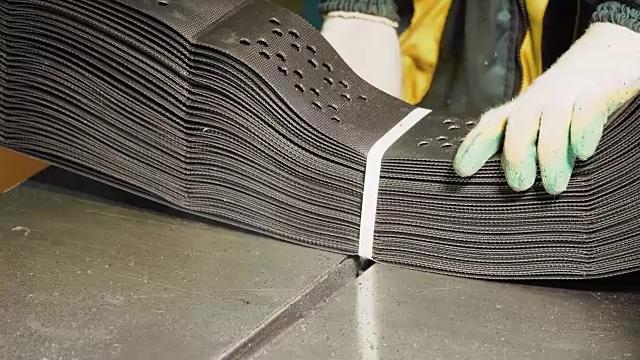 工人在工厂里拿着一堆土工格栅