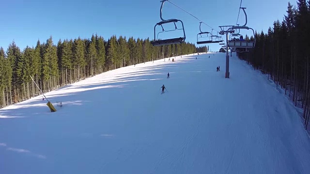 滑雪缆车把人们抬上山。滑雪者从多雪的山上下来