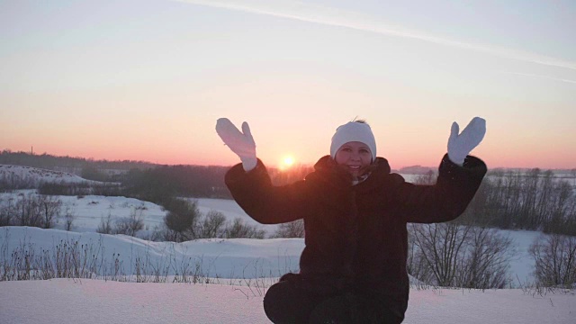 女孩在冬天的树林里散步，抛雪，微笑，大笑。在新鲜空气中散步。日落