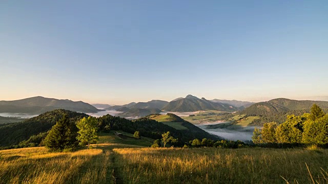 夏日乡村的日出。雾在景观山谷时间推移，摄影变焦