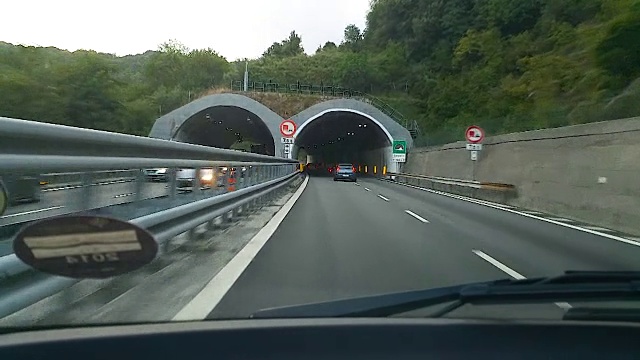 许多汽车在城外的高速公路上行驶，绕过黑暗的隧道