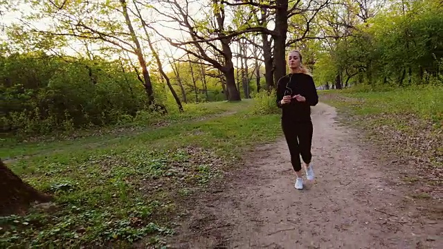 在春天的森林里慢跑。女人在森林里奔跑，阳光照在她的背上