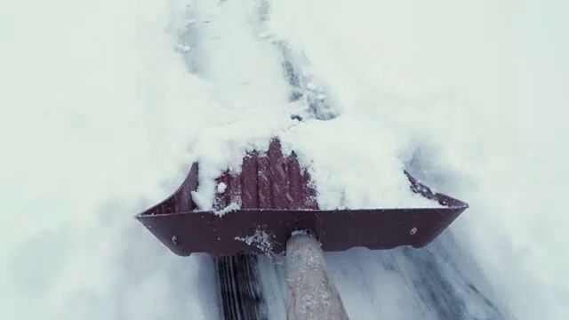 用铲子清除人行道上的积雪