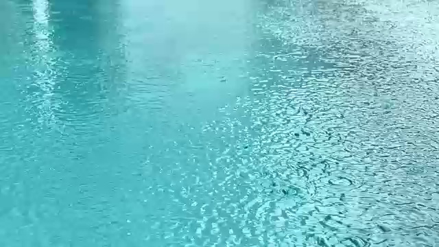 雨滴落在水面，游泳池