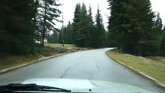 汽车在雪地上行驶在冰雪森林里的山路上