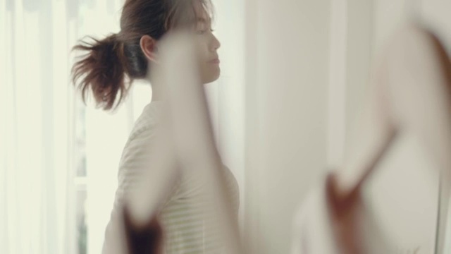 女人在家穿衣服。