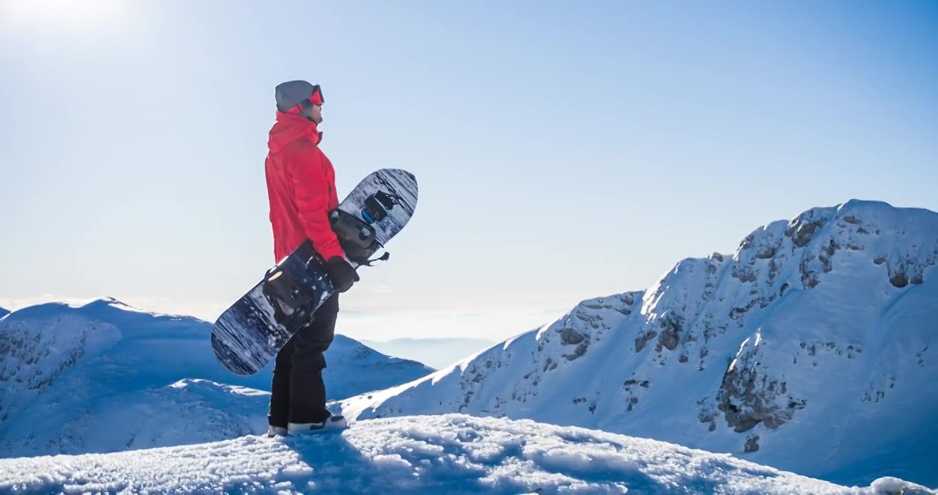 详情图-在一个阳光明媚的日子里，在山顶上玩滑雪板，欣赏冬天的风景