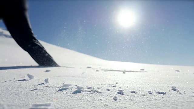 慢镜头拍摄的人走在雪山环境在阳光明媚的一天