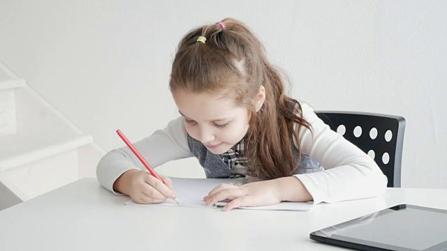 一个拿着平板电脑和书的孩子。一个女学生用纸质书和电子书学习。