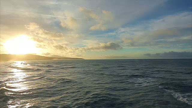 诺曼底，海面上的海浪。多云的天气和日落在海岸。蔚蓝的海水和海滩上的泡沫。在法国北部度假。行动。实时视频，晚上