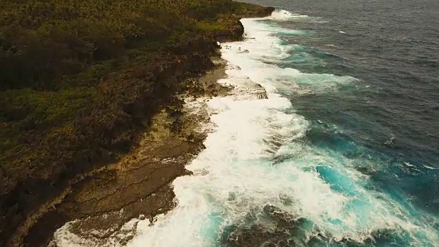 悬崖和波浪的鸟瞰图。菲律宾,Siargao