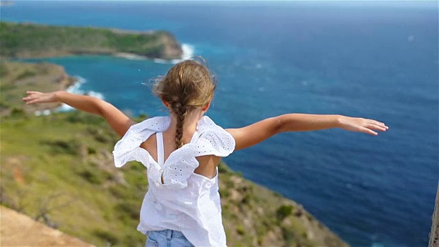 详情图-可爱的小女孩带着美丽的海湾景色像鸟儿一样飞翔
