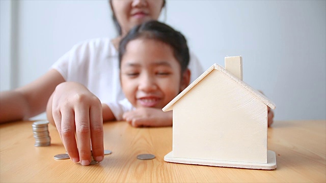详情图-4K妈妈和亚洲小女孩把钱硬币到房子小猪储蓄罐选择重点房子