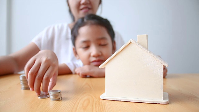 详情图-4K妈妈和亚洲小女孩把钱硬币到房子小猪储蓄罐选择重点房子