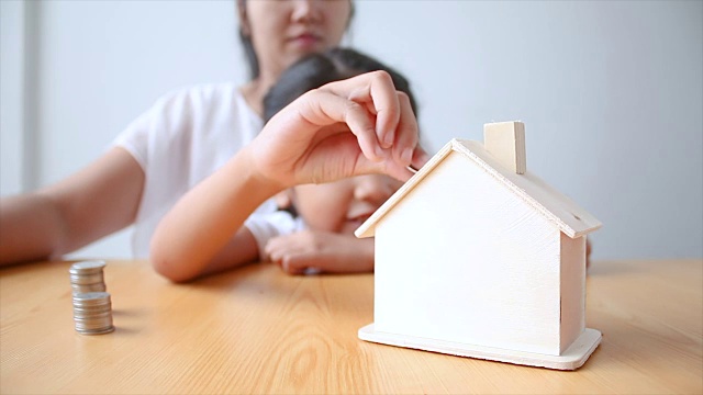 详情图-4K妈妈和亚洲小女孩把钱硬币到房子小猪储蓄罐选择重点房子