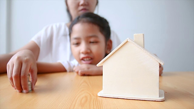 详情图-4K妈妈和亚洲小女孩把钱硬币到房子小猪储蓄罐选择重点房子