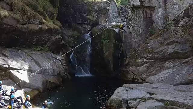 攀岩者跳入瀑布的跳水池