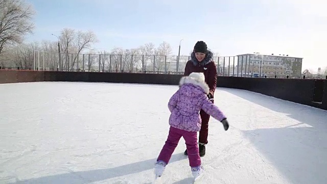 妈妈教女儿溜冰。