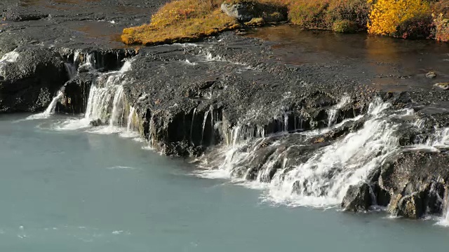 清澈的水从岩石流进湍急的浅蓝色山河