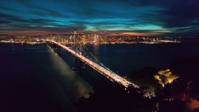 夜间海湾大桥和旧金山天际线的空中城市景观视频