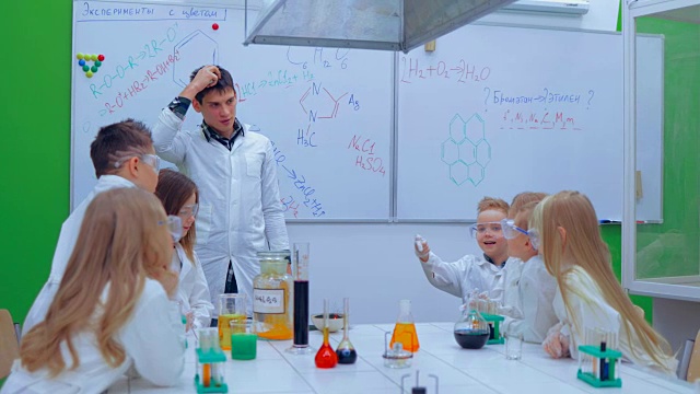 老师和小朋友在上化学课。学生和老师在科学课上观看实验